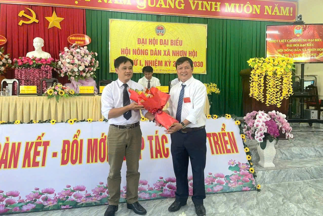 Ông Phan Văn Thoại, Chủ tịch Hội nông dân xã tặng hoa cho ông Huỳnh Văn Thích- Phó bí thư Thường trực đảng ủy xã